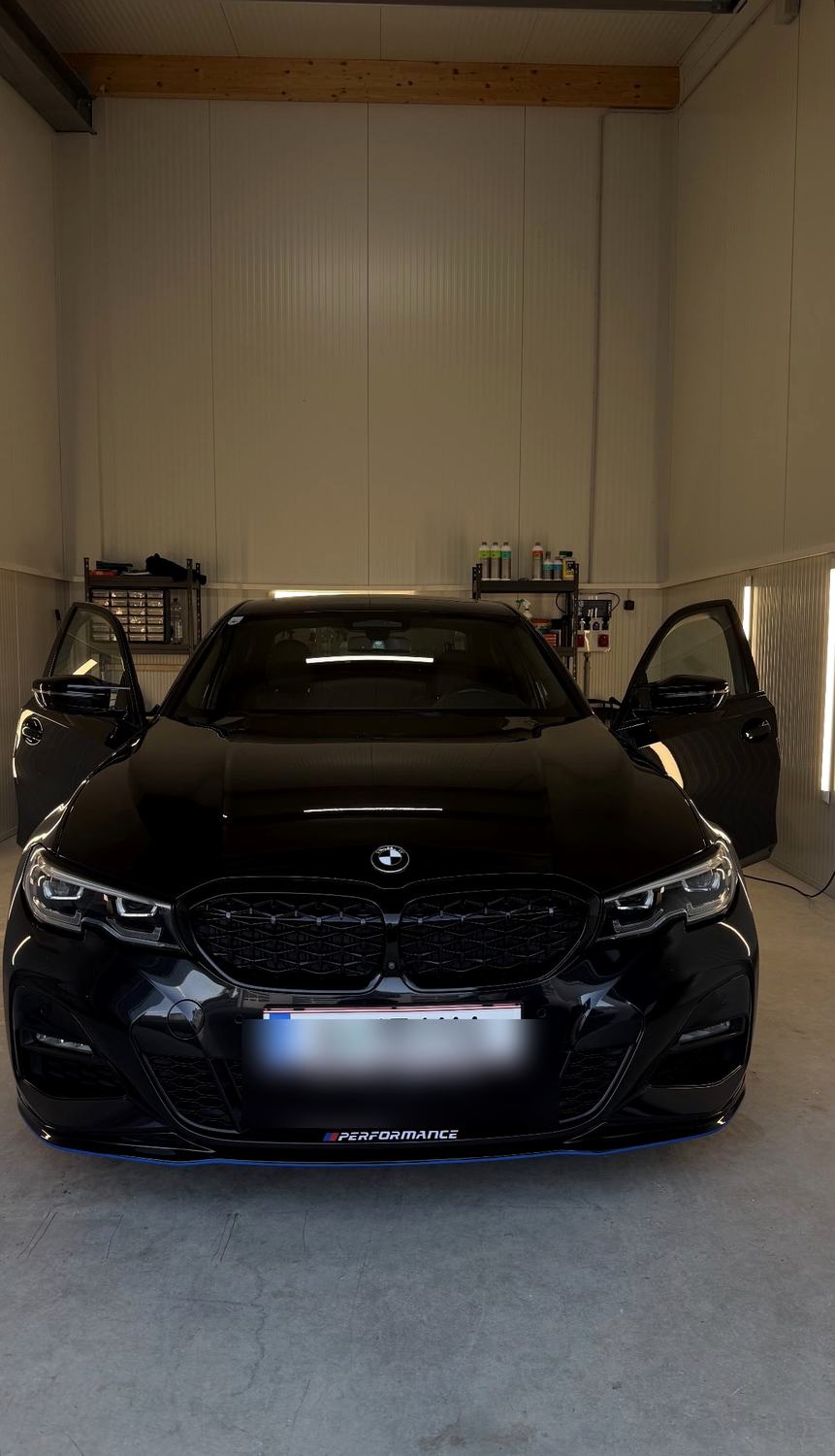 Schwarzer BMW 3er in der Halle, Türen offen