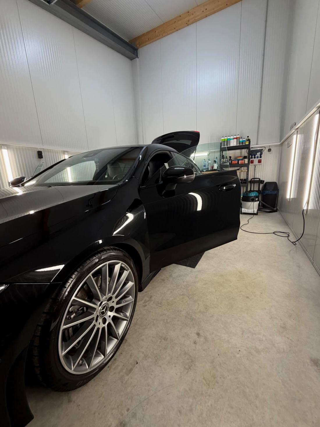 Schwarzer Mercedes CLA in der Halle, Türen offen